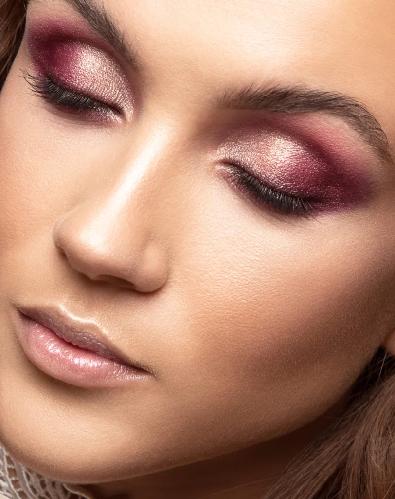 Gros plan beauté, yeux fermés, mettant en valeur un maquillage prune irisé.