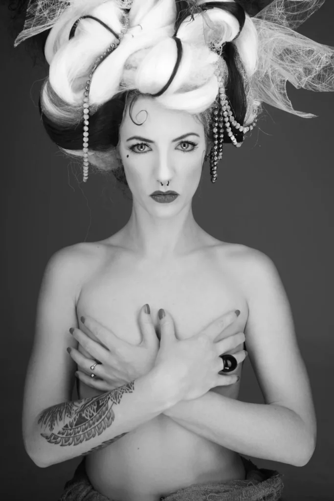 Portrait conceptuel en noir et blanc avec coiffure sculpturale et pose graphique.
